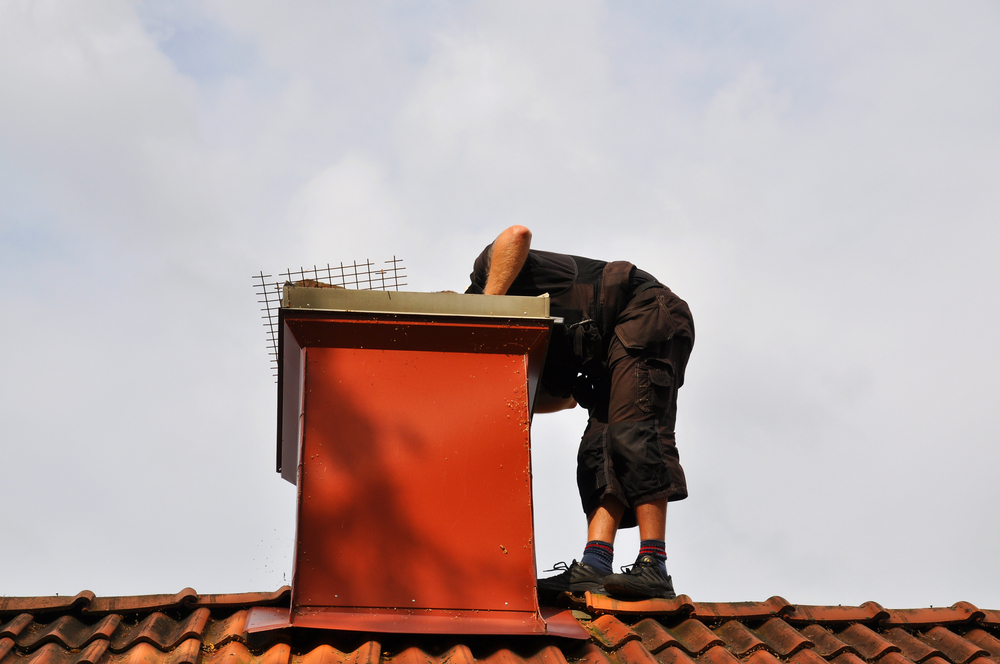Unrecognizable,Modern,Chimney,Sweep,Checking,Out,The,Chimney,From,The