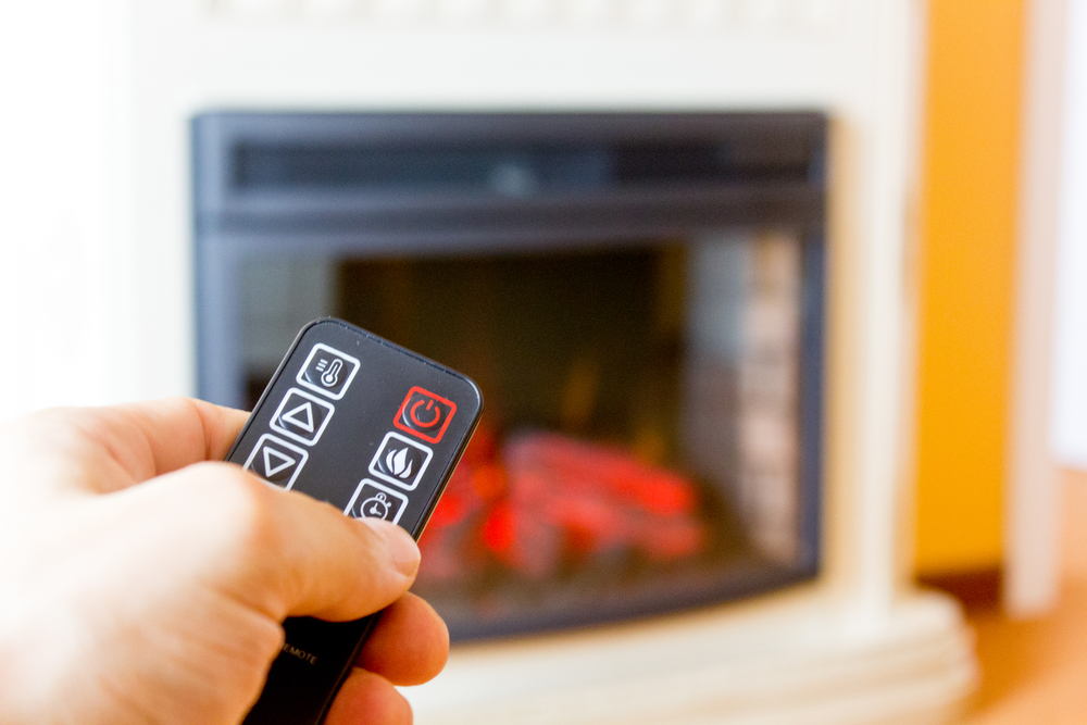 Electric,Fireplace,Remote,Control,In,Human,Hand.